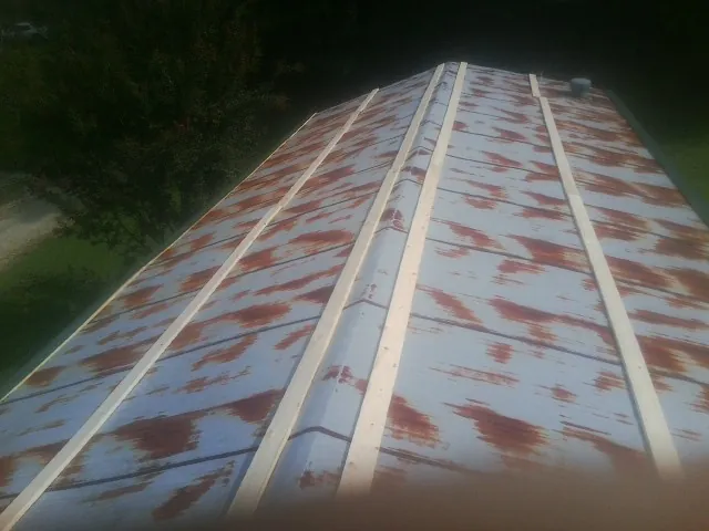 Rusted metal roof panels with new wood purlins before replacement — Storm Damage Roof Repair in New Franken by Roofing Brothers