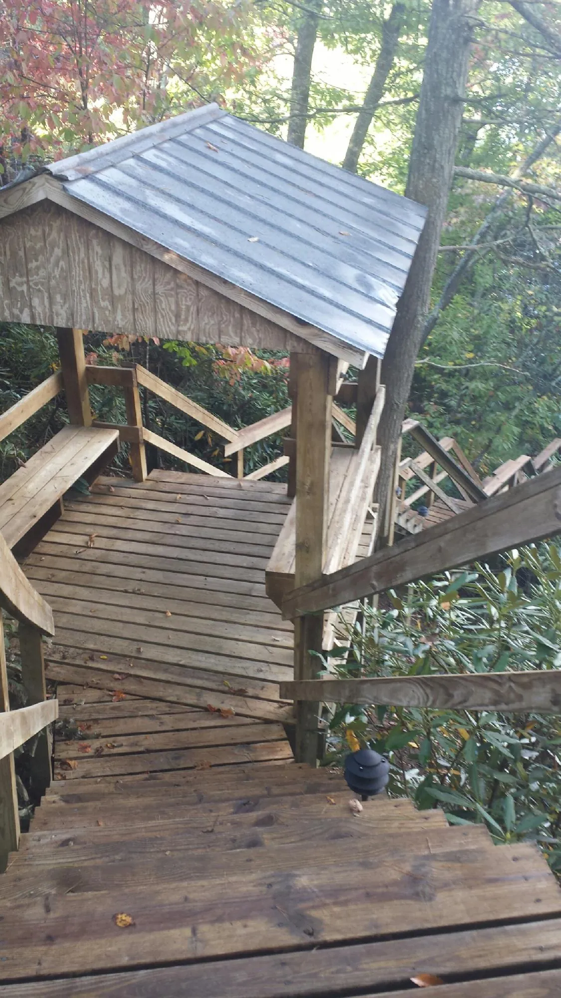 Metal roofed shelter over wooden steps on a wooded walkway — Skylight Repair & Installation work by our crew in New Franken