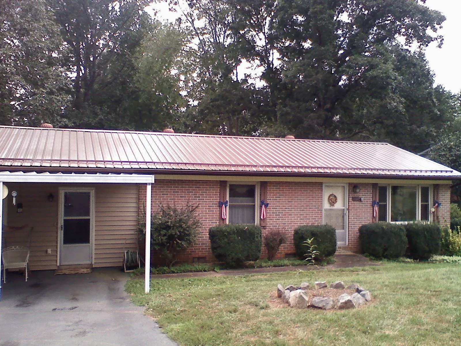 Bronze metal roof and carport on a brick ranch home — Roof Repair work by our crew in New Franken